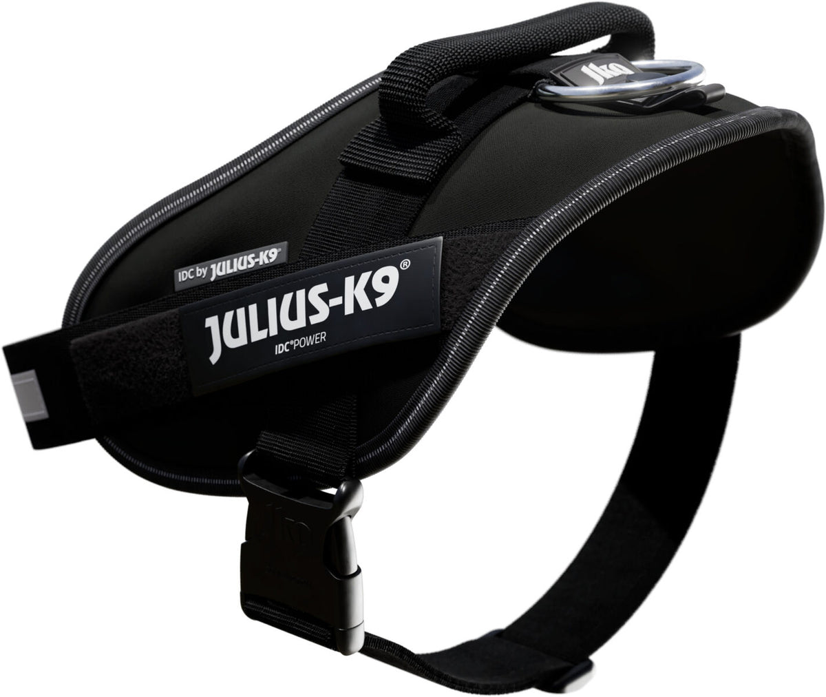Schwarzes Hundegeschirr mit verstärktem Griff und sichtbarem "Julius-K9" Logo, seitlich abgebildet.