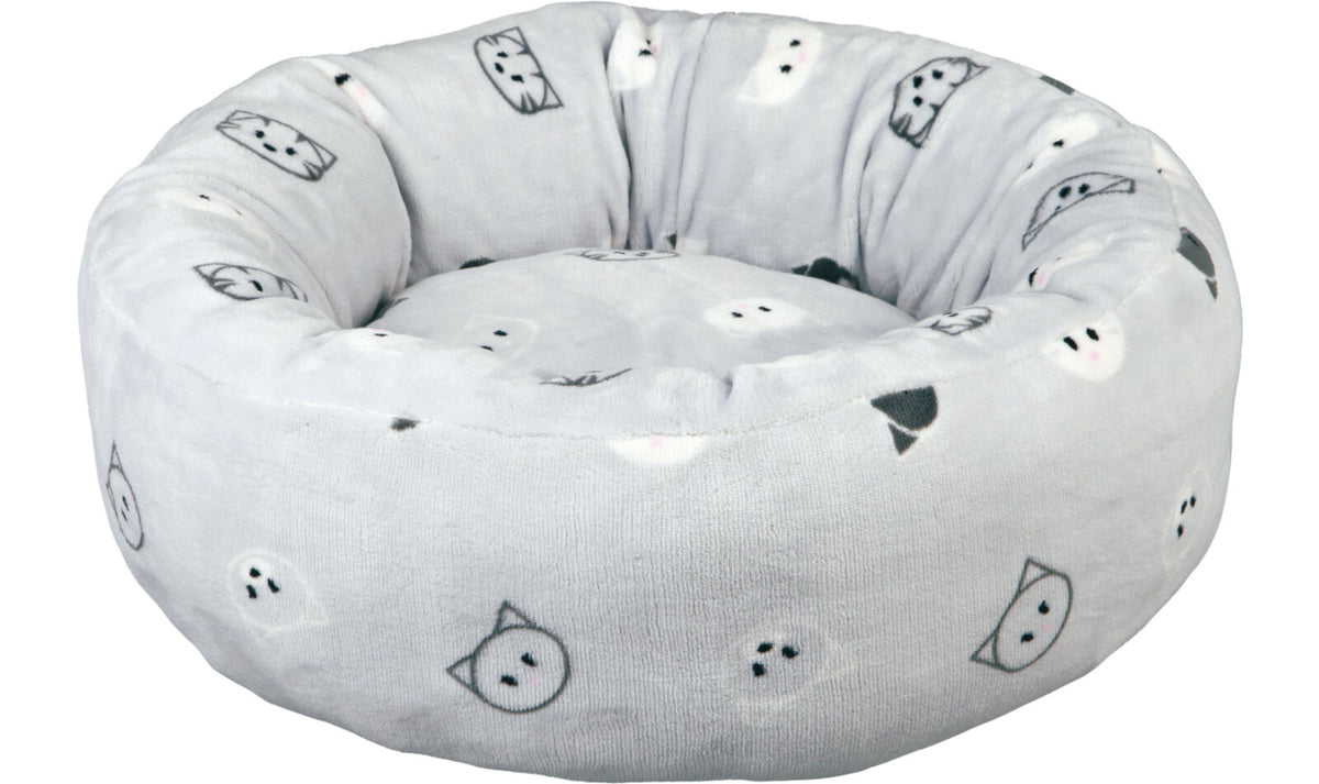 Rundes, graues, gepolstertes Bett mit schwarzen und weißen Katzengesichtern als Muster.
