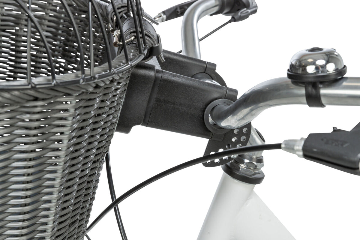 Fahrradkorb aus grauem Geflecht an silbernen Lenker befestigt, daneben eine silberne Klingel.