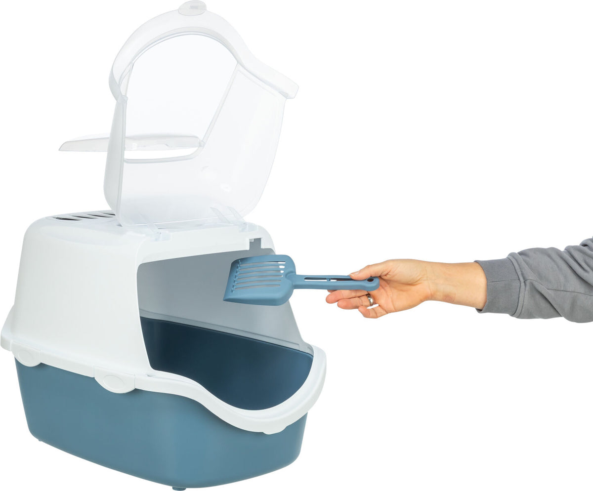 Geschlossene Katzentoilette mit Haube und Schaufel, die von Hand gehalten wird; Farben sind Weiß und Blau.