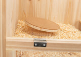 Holzbox mit Hobelspänen, darin ein rundes Brett auf einer erhöhten Basis.
