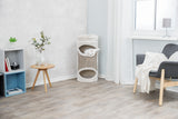Helles Wohnzimmer mit Holzfußboden, ein grauer Sessel, ein runder Holztisch, ein Regal und ein Kratzbaum mit einer weißen Katze.