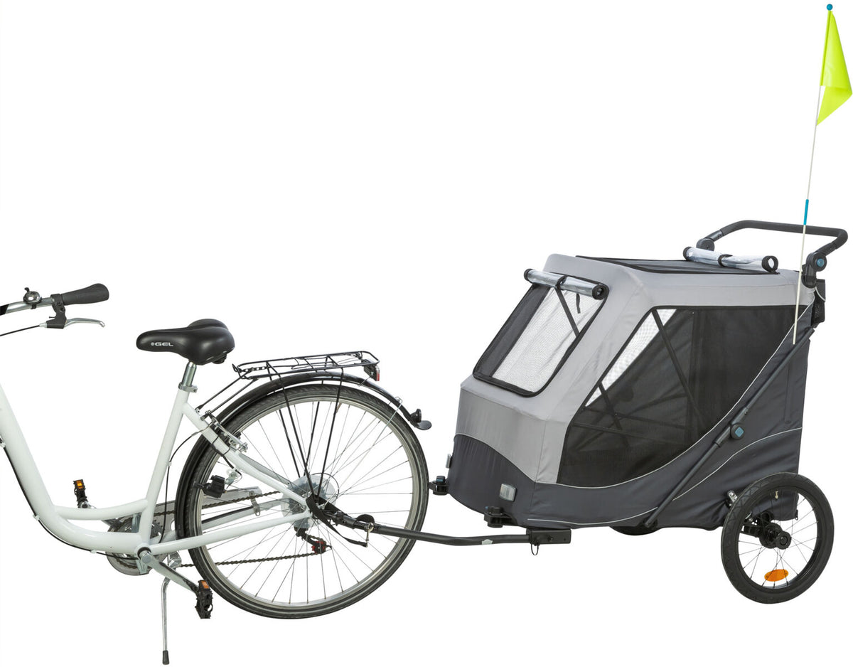 Silbernes Fahrrad mit angeschlossenem grauem Fahrradanhänger, schwarzes Netzfenster, gelbe Sicherheitsfahne.