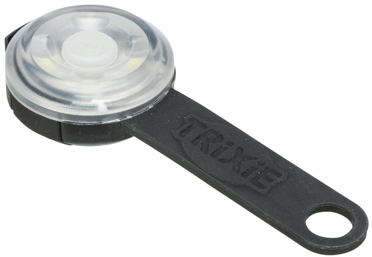 Rundes, transparentes Blinklicht mit schwarzem Gummiband, darauf der Schriftzug "Trixie" erkennbar.