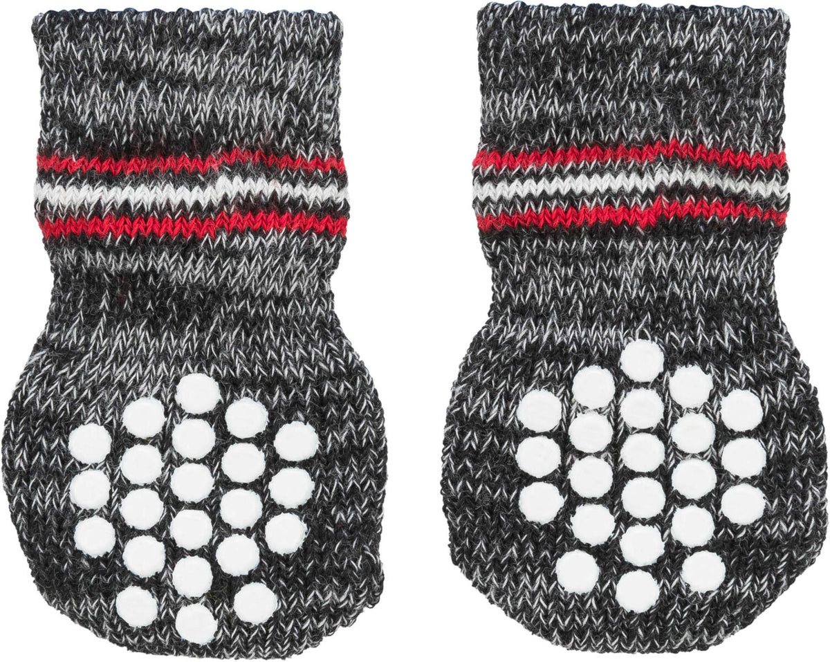 Zwei dunkelgraue Stricksocken mit roten und weißen Streifen sowie weißen runden Noppen auf den Sohlen.