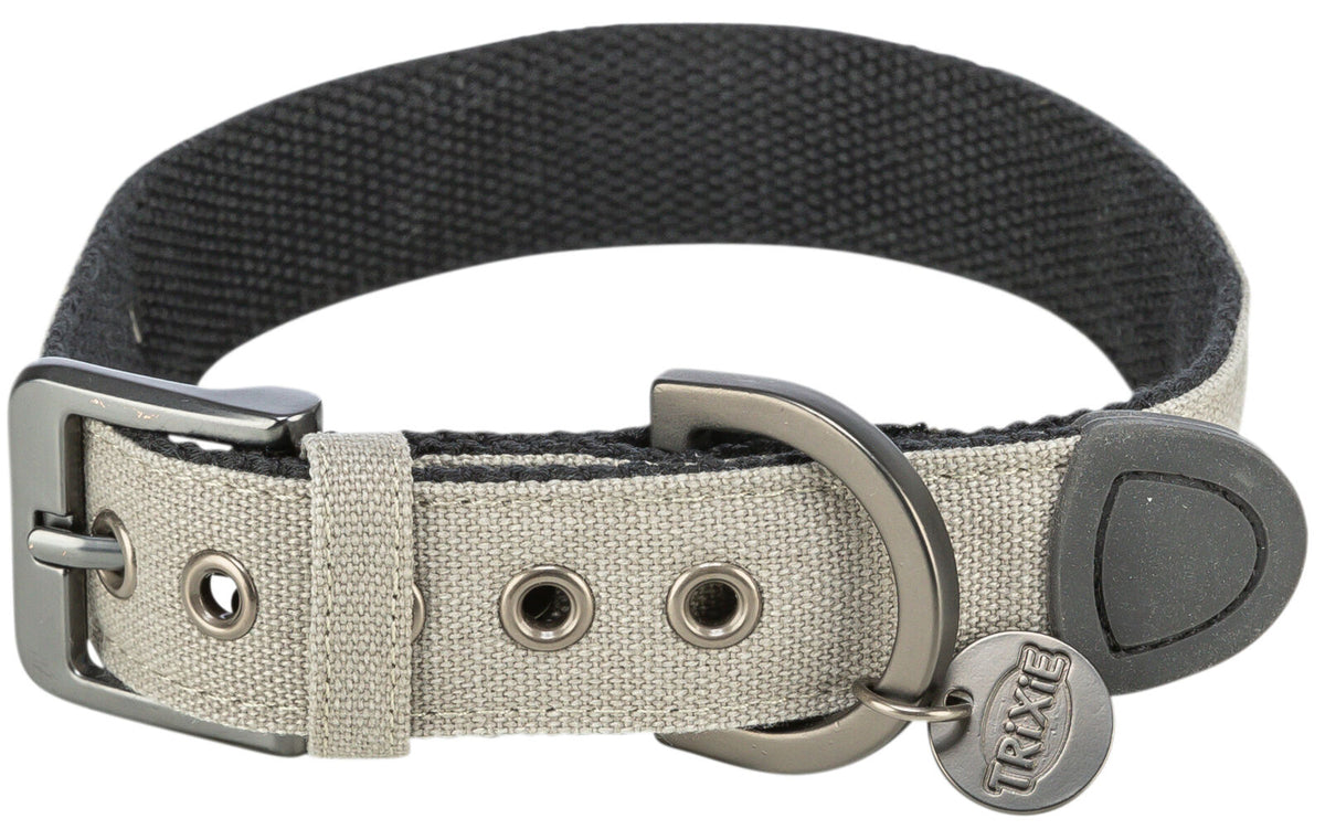Ein beige-graues Hundehalsband mit Metallschnalle, Ösen, D-Ring und einem Trixie-Logo am Anhänger.