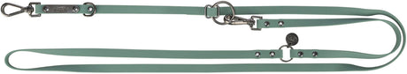 Grüne Hundeleine mit Metallbeschlägen, Ringen und Karabinern, aufgedruckter Schriftzug "TRIXIE".