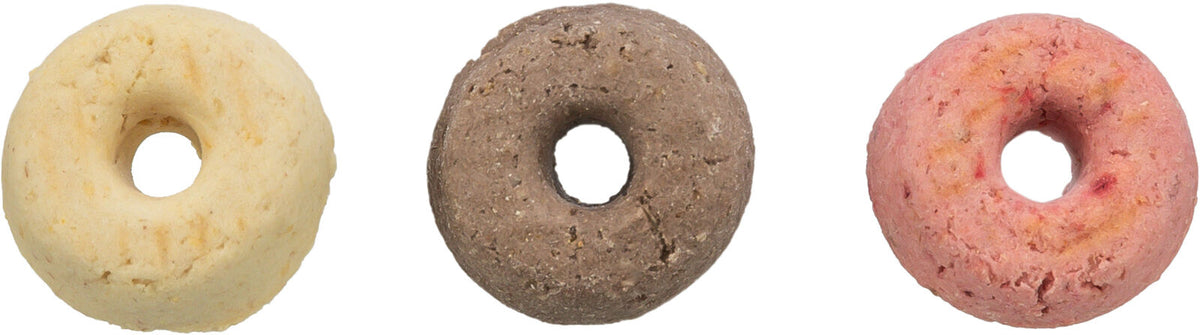 Drei runde, donutförmige Objekte in Beige, Braun und Rosa mit Loch in der Mitte auf weißem Hintergrund.