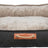 Hundebett mit dunkelgrauem Stoffbezug und heller, weicher Innenseite, vorne mit braunem Lederdetail und Seilgriff.