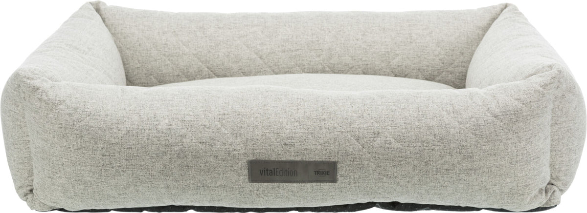 Rechteckiges, hellgraues Hundebett mit erhöhtem Rand und sichtbarem Etikett mit der Aufschrift "vitalEdition TRIXIE".