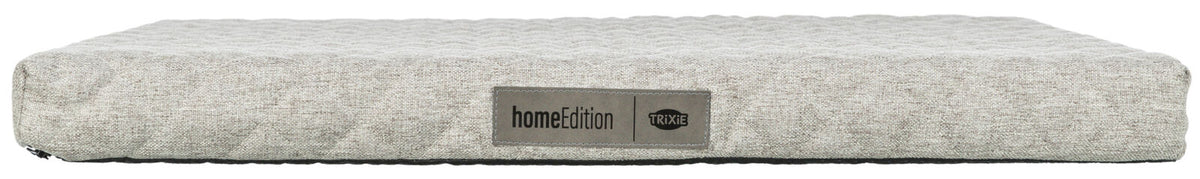 Graues, rechteckiges Kissen mit dezenter Textur, seitlich ein Etikett mit der Aufschrift "home Edition TRIXIE".