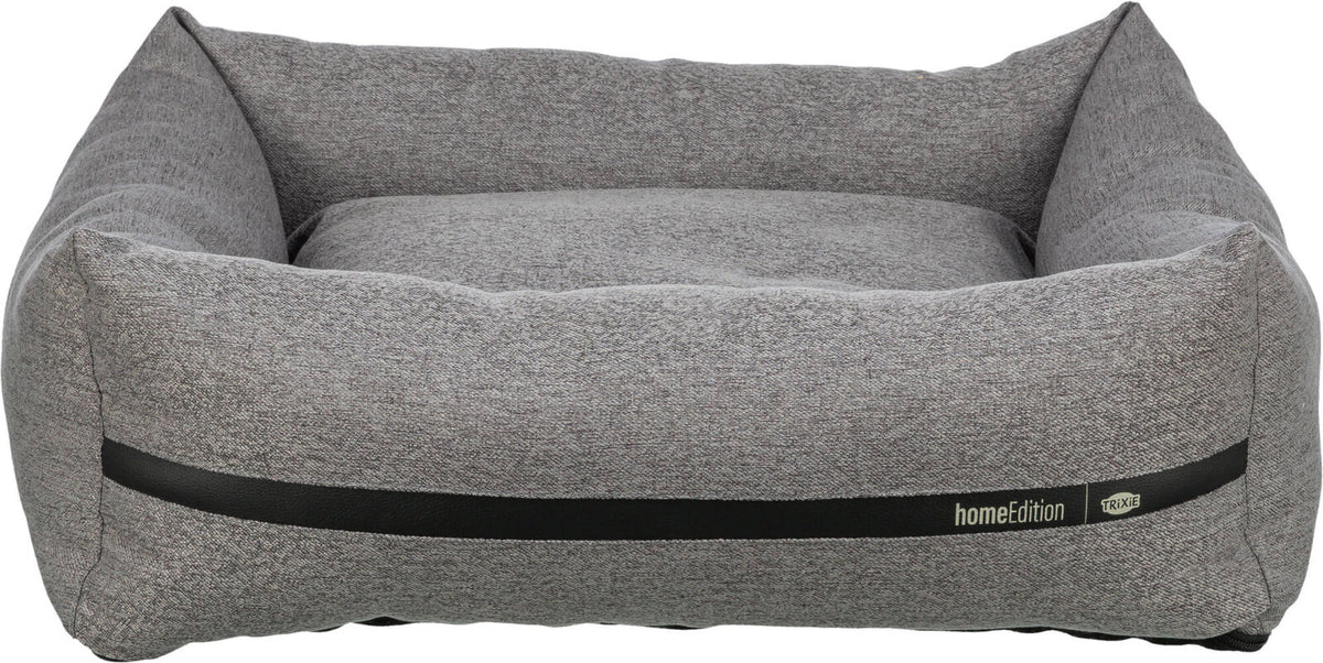 Graues, rechteckiges Hundebett mit erhöhtem Rand, Textur sichtbar, schwarzer Streifen, Aufschrift "homeEdition Trixie".