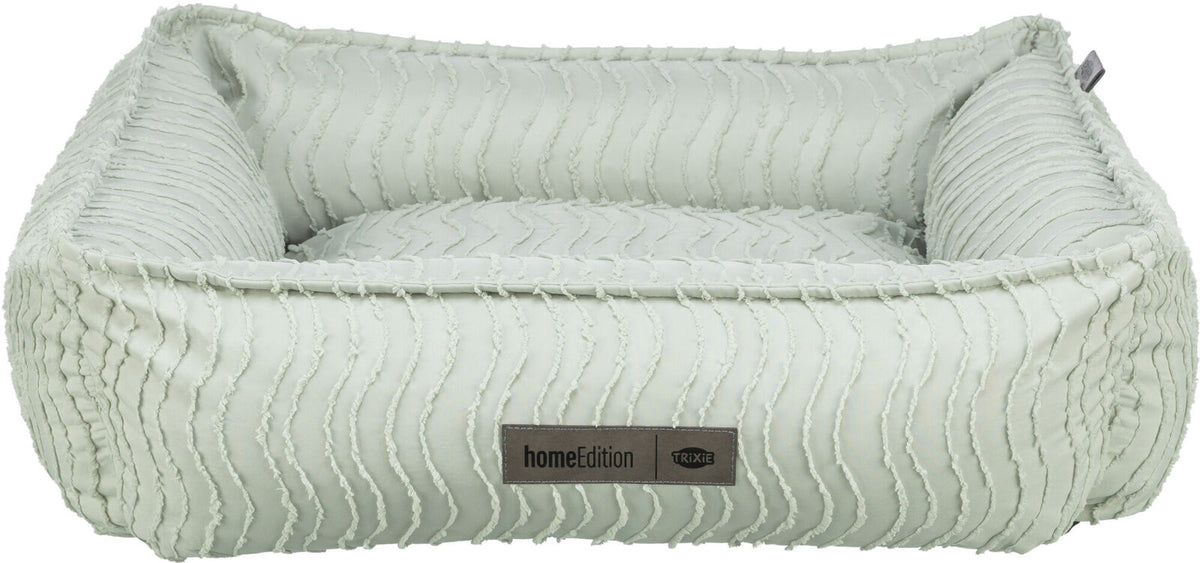 Rechteckiges, pastellgrünes Haustierbett mit wellenartiger Struktur und einem Label "homeEdition Trixie".