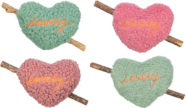 Vier herzförmige, flauschige Kissen in Grün und Rosa mit dem Wort "Lovely" darauf, an einem Holzstab befestigt.