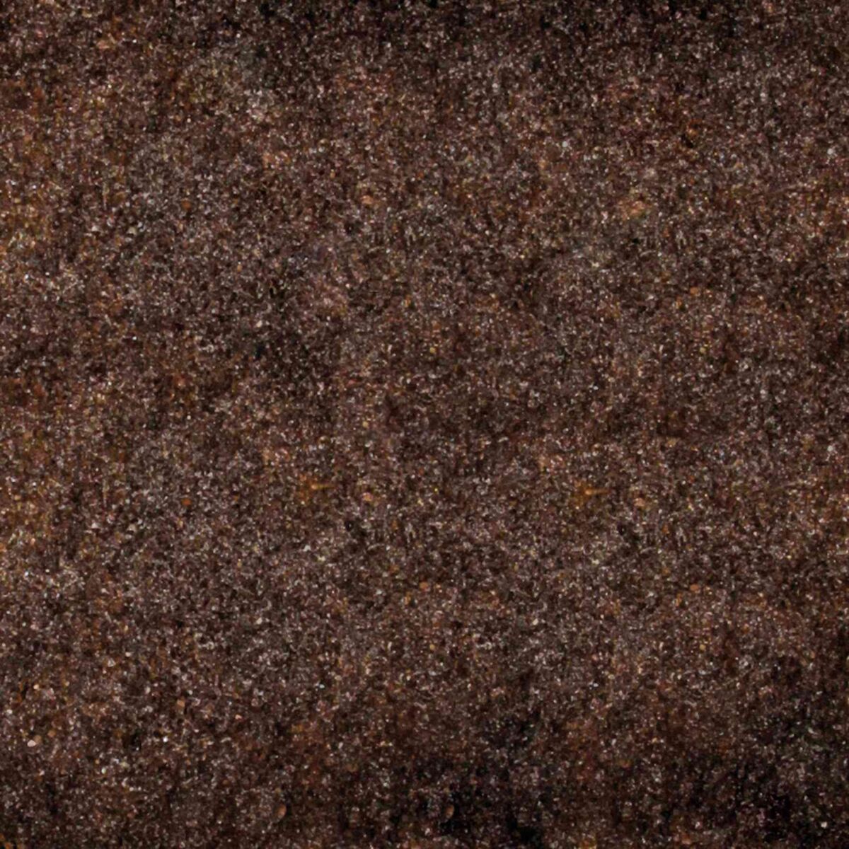 Eine grobkörnige, dunkelbraune Oberfläche mit einer ungleichmäßigen Textur.