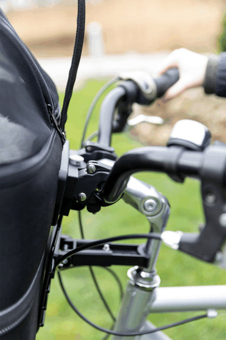 Nahaufnahme eines Fahrradlenkers mit handbedientem Bremshebel und schwarzer Lenkerhalterung im Hintergrund.