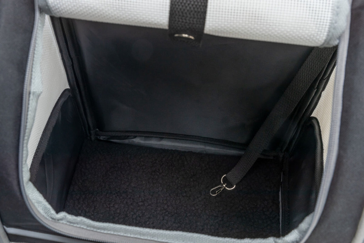 Innenansicht eines schwarzen, gepolsterten Transportbehälters mit Wänden in Weiß und einer Befestigungsschlaufe.