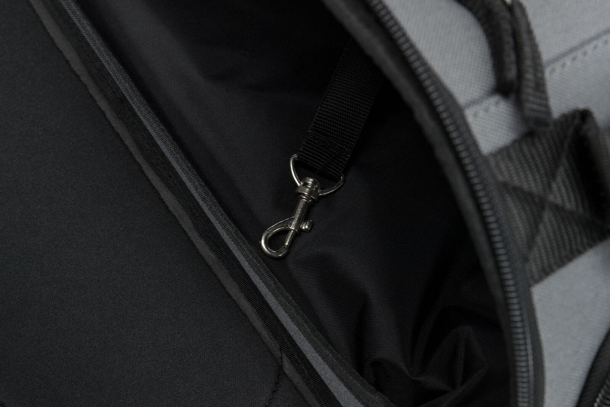 Schwarzer Innenraum einer Tasche oder eines Rucksacks mit einer Metallkarabinerhaken befestigt an einem Gurtband.