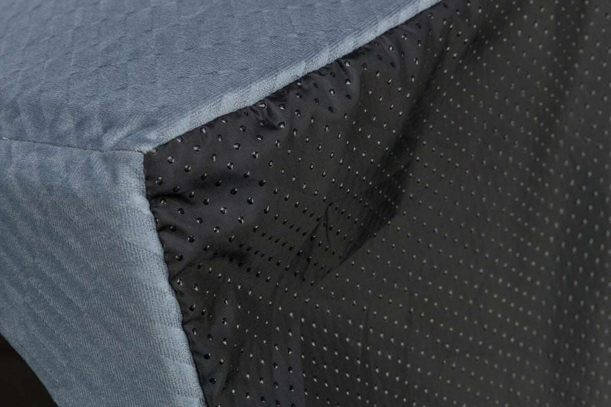 Ecke einer grauen gesteppten Oberfläche mit schwarzen, gepunkteten Seiten.