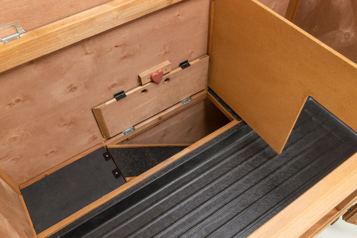Holzkiste mit offenem Deckel zeigt Innenraum mit Holz- und Metallteilen, Herzgriff und schwarzen Bodenplatten.