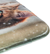 Weiches Kissen mit verschwommenem Katzendruck in Braun- und Beigetönen, Schneeflockenmotiv im Hintergrund.